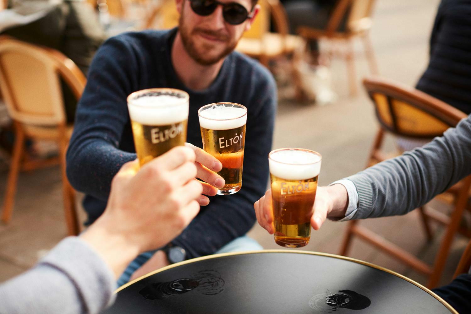 mannen genieten van een pintje op zonnig terras van bar Eltòn