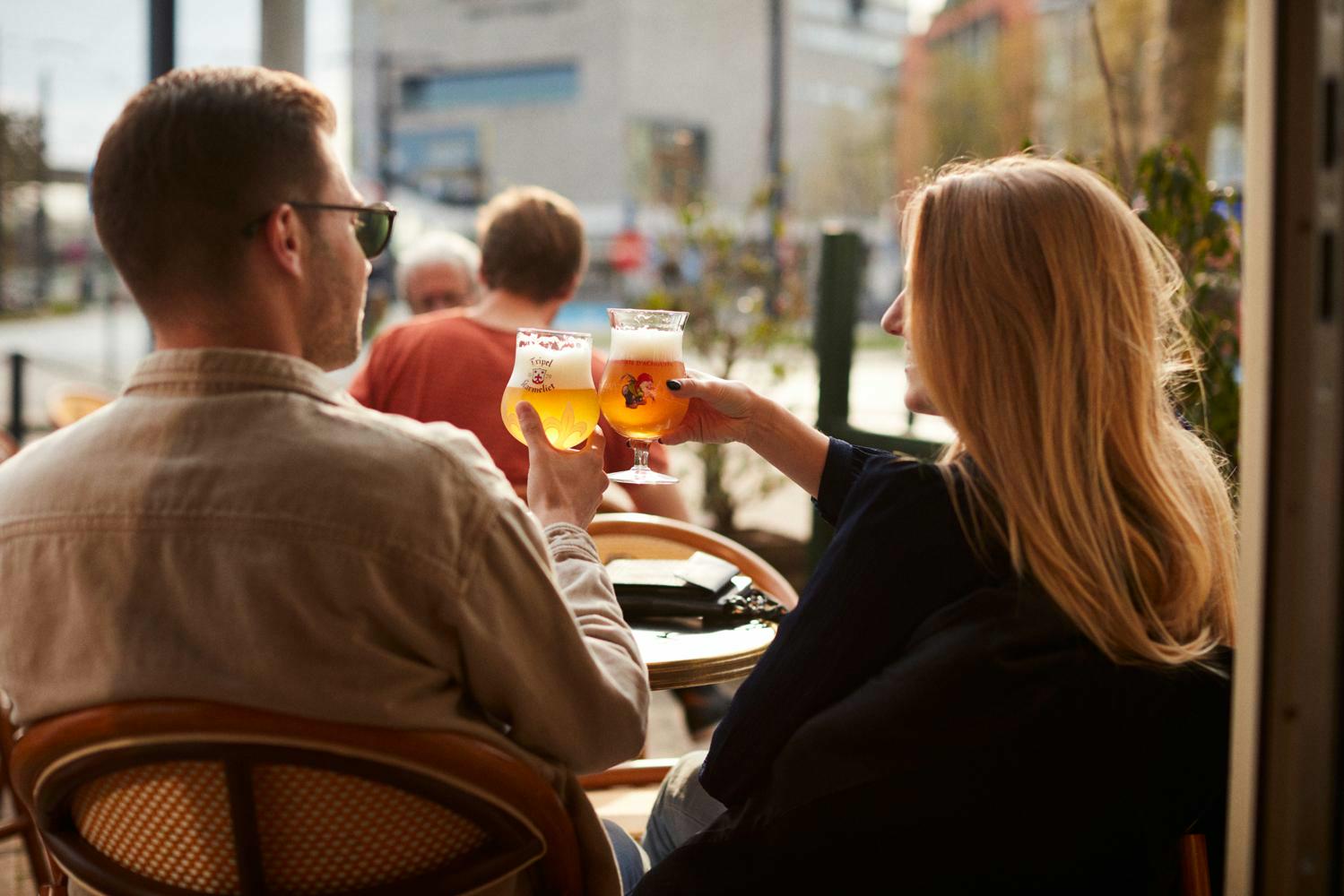 mensen klinken met La Chouffe op zonnig terras van bar Eltòn aan Gent-Sint-Pieters
